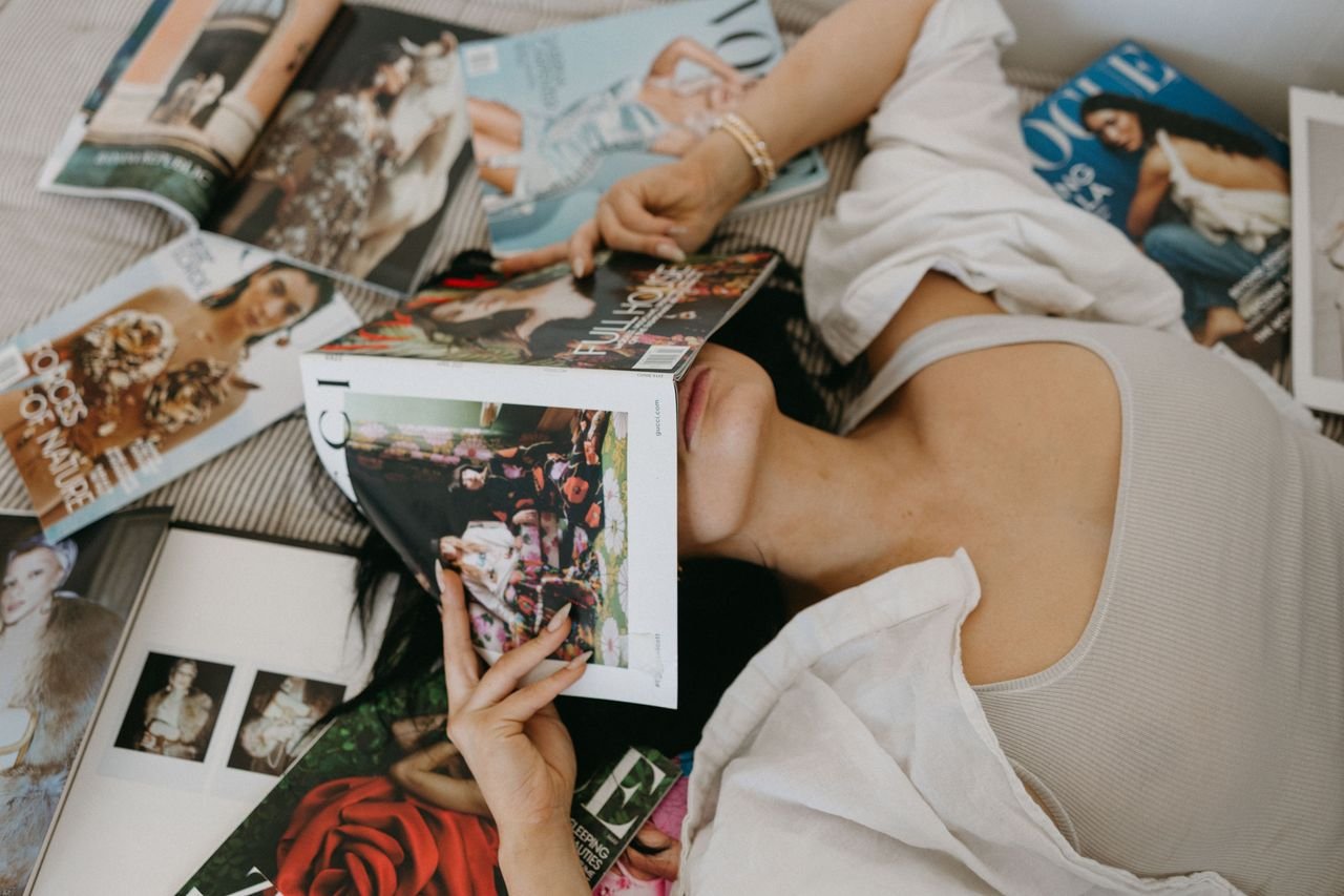 services-img A woman reads fashion magazines, evoking a relaxing lifestyle and fashion mood.